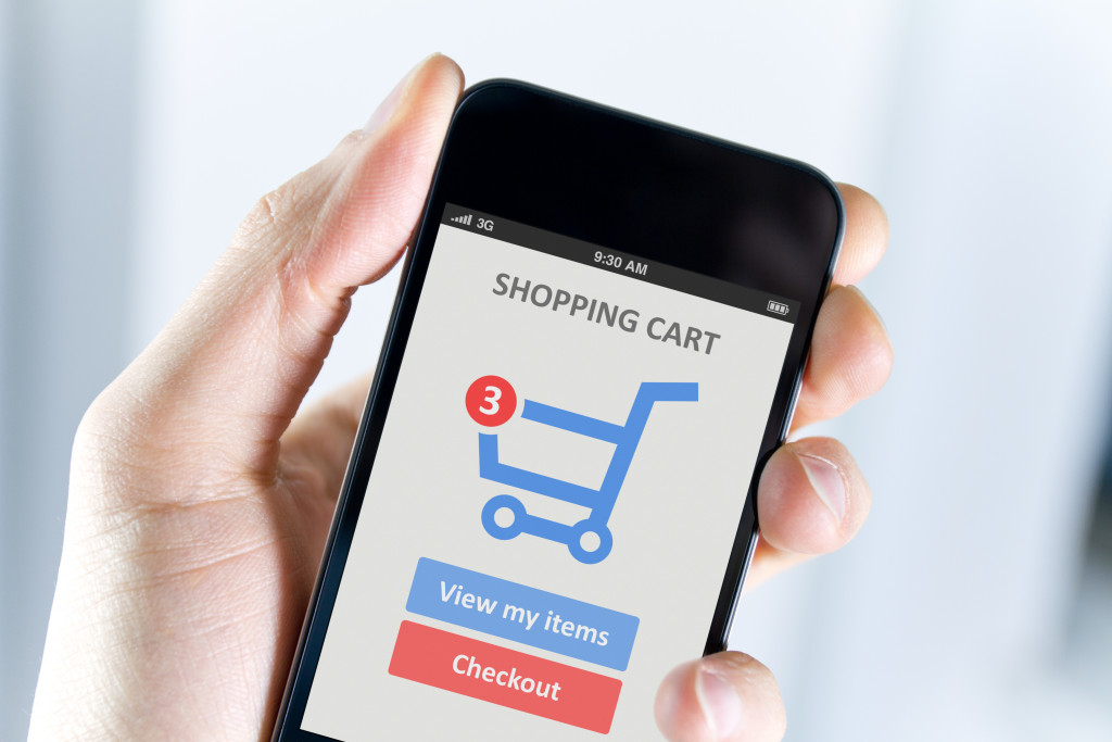 a person holding a mobile phone browsing a shopping cart page