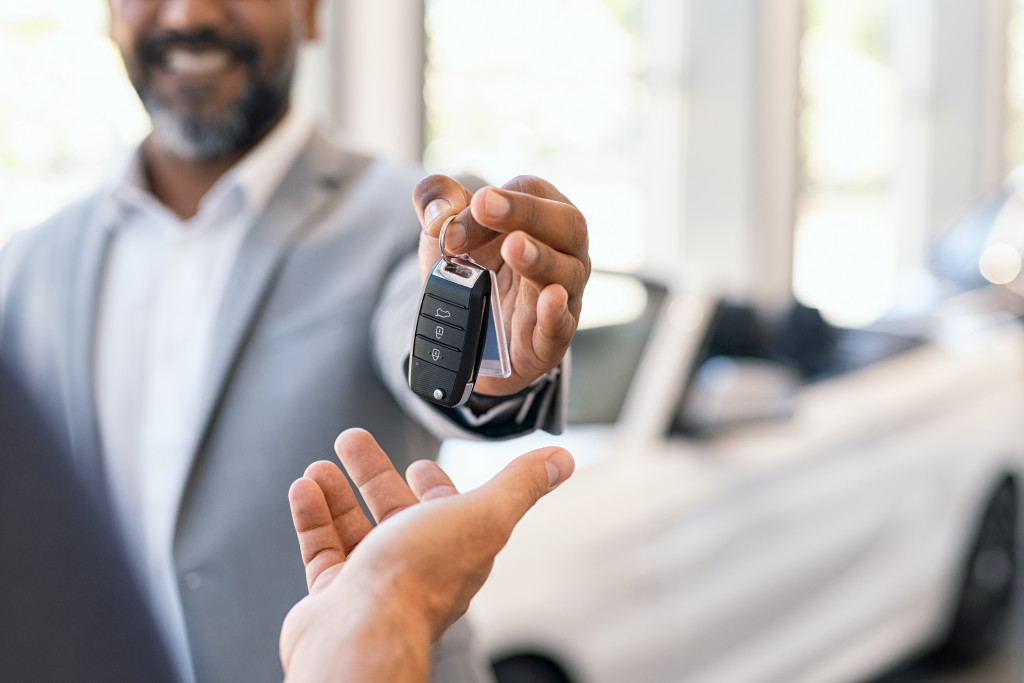 person handing over a car key