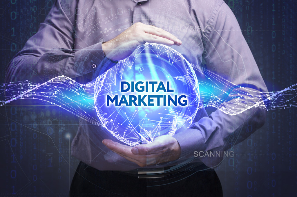 The words digital marketing in a sphere held by a businessman.