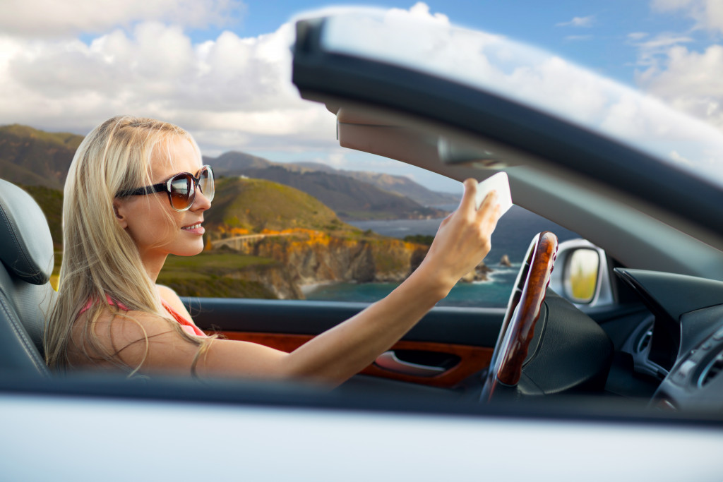 woman taking a selfie while driving her car