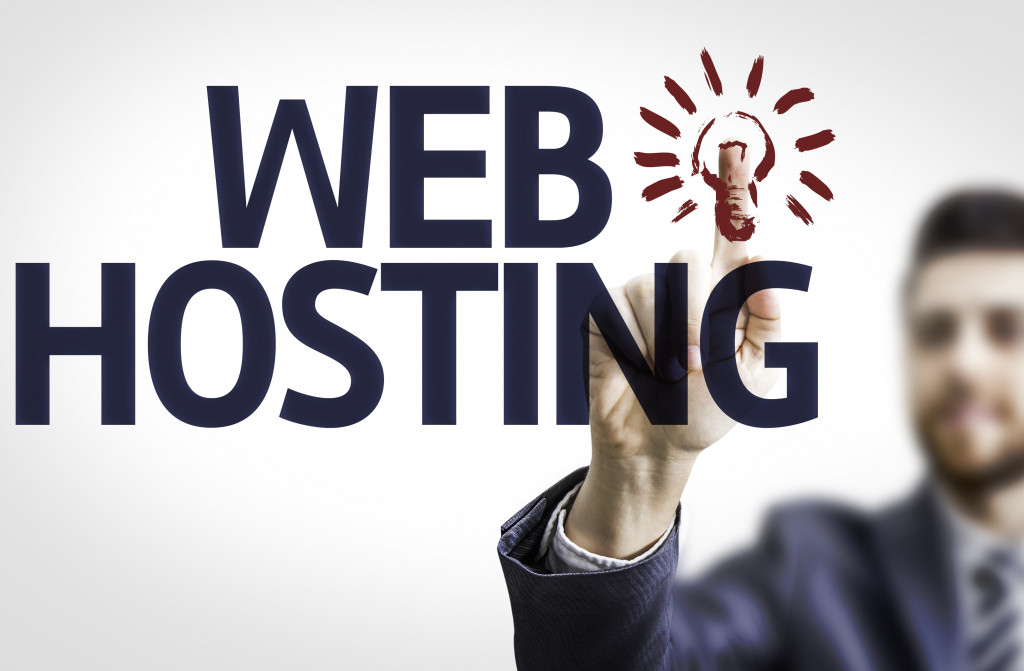 A businessman touching the word Web Hosting with a light bulb